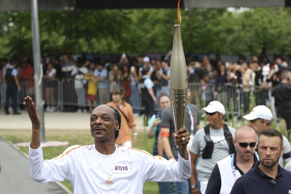 Snoop Dogg carries the Olympic torch before opening ceremony in Paris