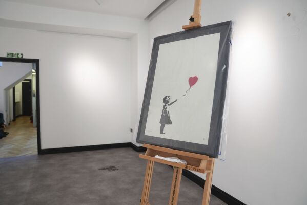 2 men charged with stealing a famous Banksy image from a London art gallery